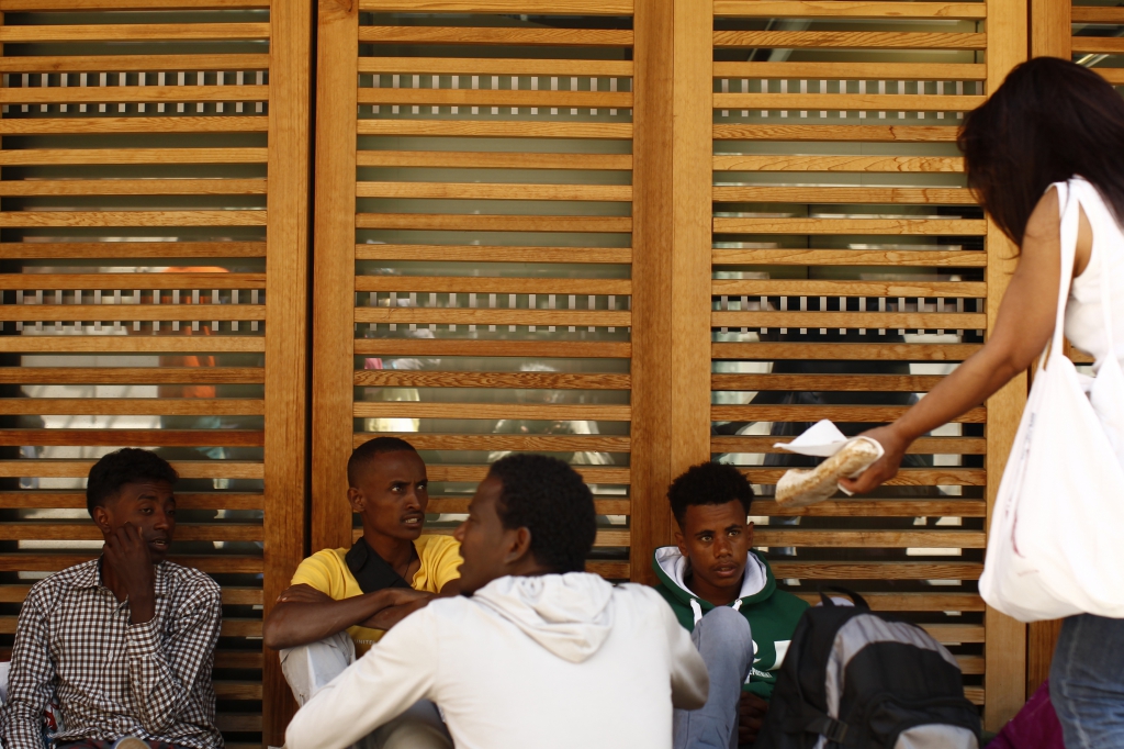 LC1225400 <br>migrants erythreens sur le parvis de la gare de Nice , Honorina sensible à l'odyssey de ces candidats à l'emigrations distribue du pain <br>