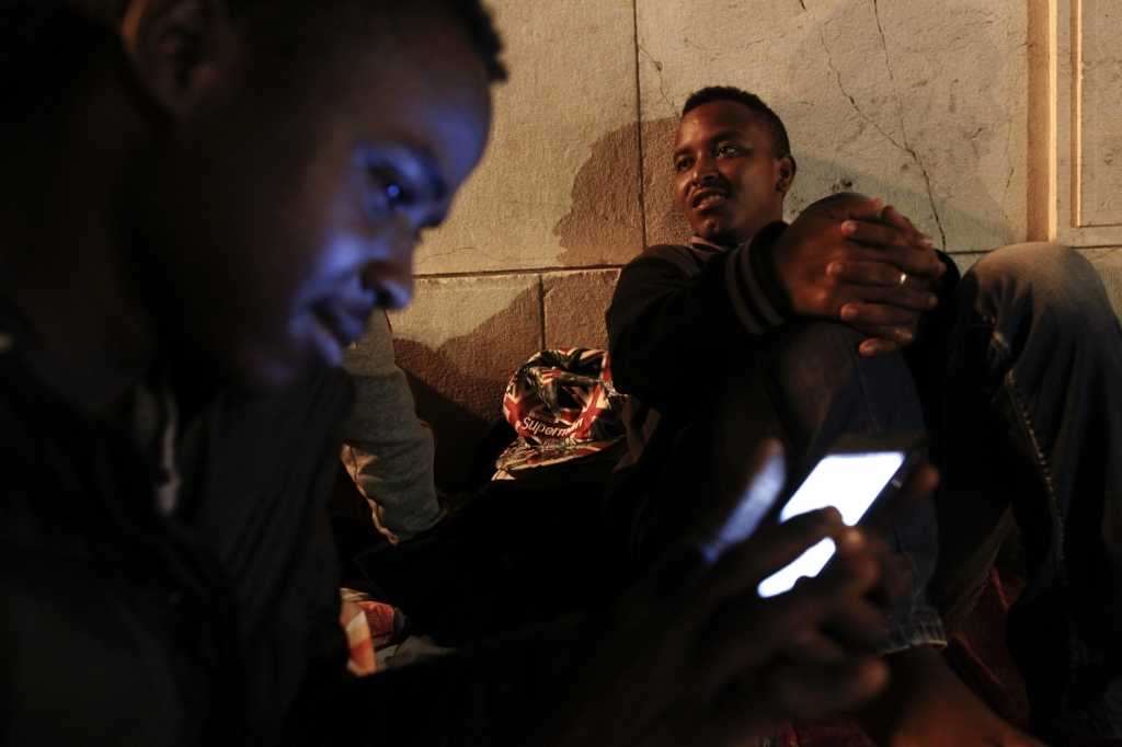 LC1225404 <br>Karem le soudanais ainsi que Abel consultent leur compte Facebook apres s 'etre fait preter un téléphone sur le parvis de la gare de Nice<br>